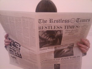 Picture of Hannah reading a copy of the Restless Times
